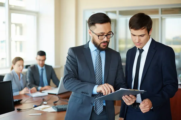Empresarios revisando información para delegar decisiones